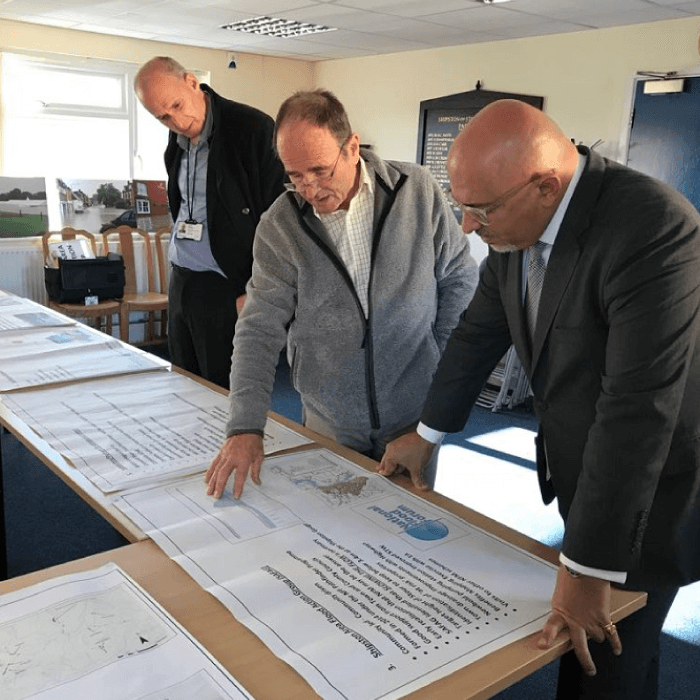 Two members of SAFAG pour over charts and schematics with local MP Mr. Nadhim Zahawi.